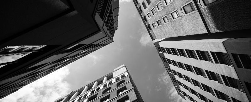 Looking up to the sky between tall office buildings